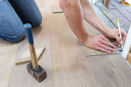 person taking measurements on a vinyl floor