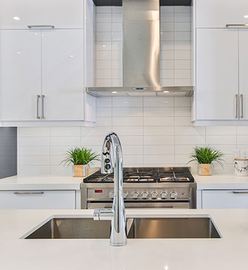 home kitchen with stainless steel oven, white cabinets, and an island